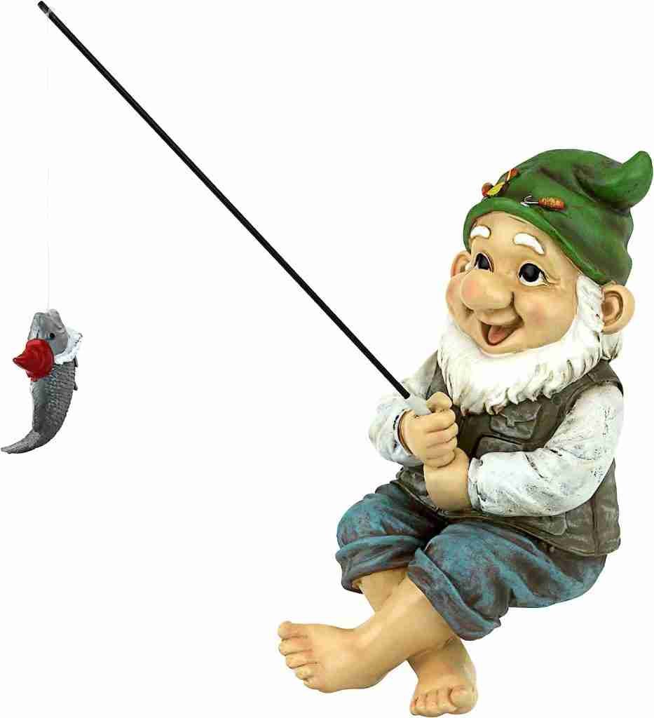 Garden gnome statue with a green hat and white beard, sitting and holding a fishing rod with a fish on the line.