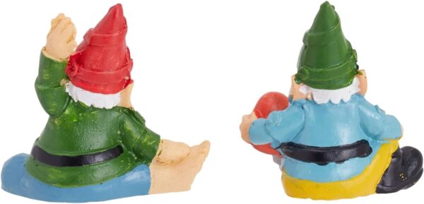 Two small figurines of gnomes with their backs facing the viewer, one with a red hat in green clothes and the other with a green hat in blue and yellow clothes.