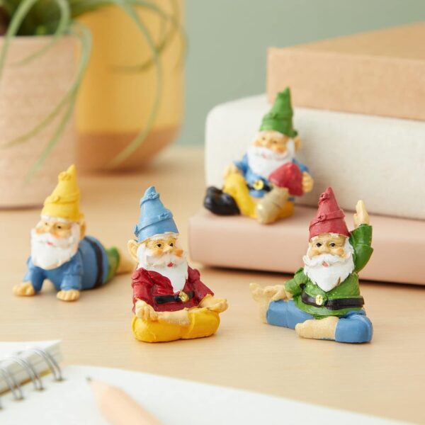 Miniature gnome figurines in various poses placed on a desk with books and a plant in the background.