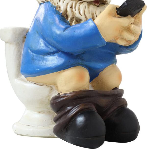 Garden gnome figurine sitting on a toilet, wearing a blue coat and holding a smartphone.